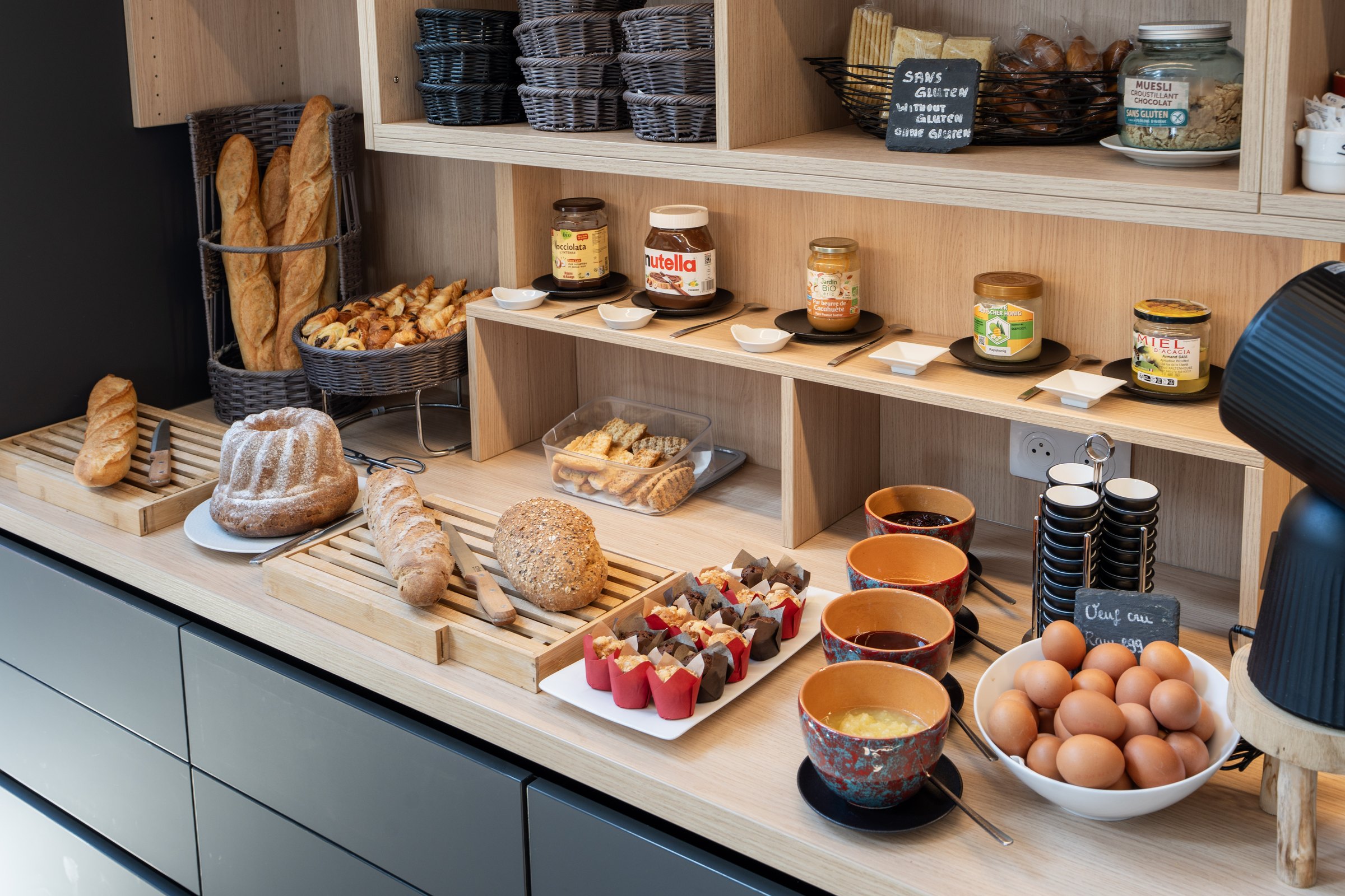 Breakfast buffet with bread, pastries, eggs and jams