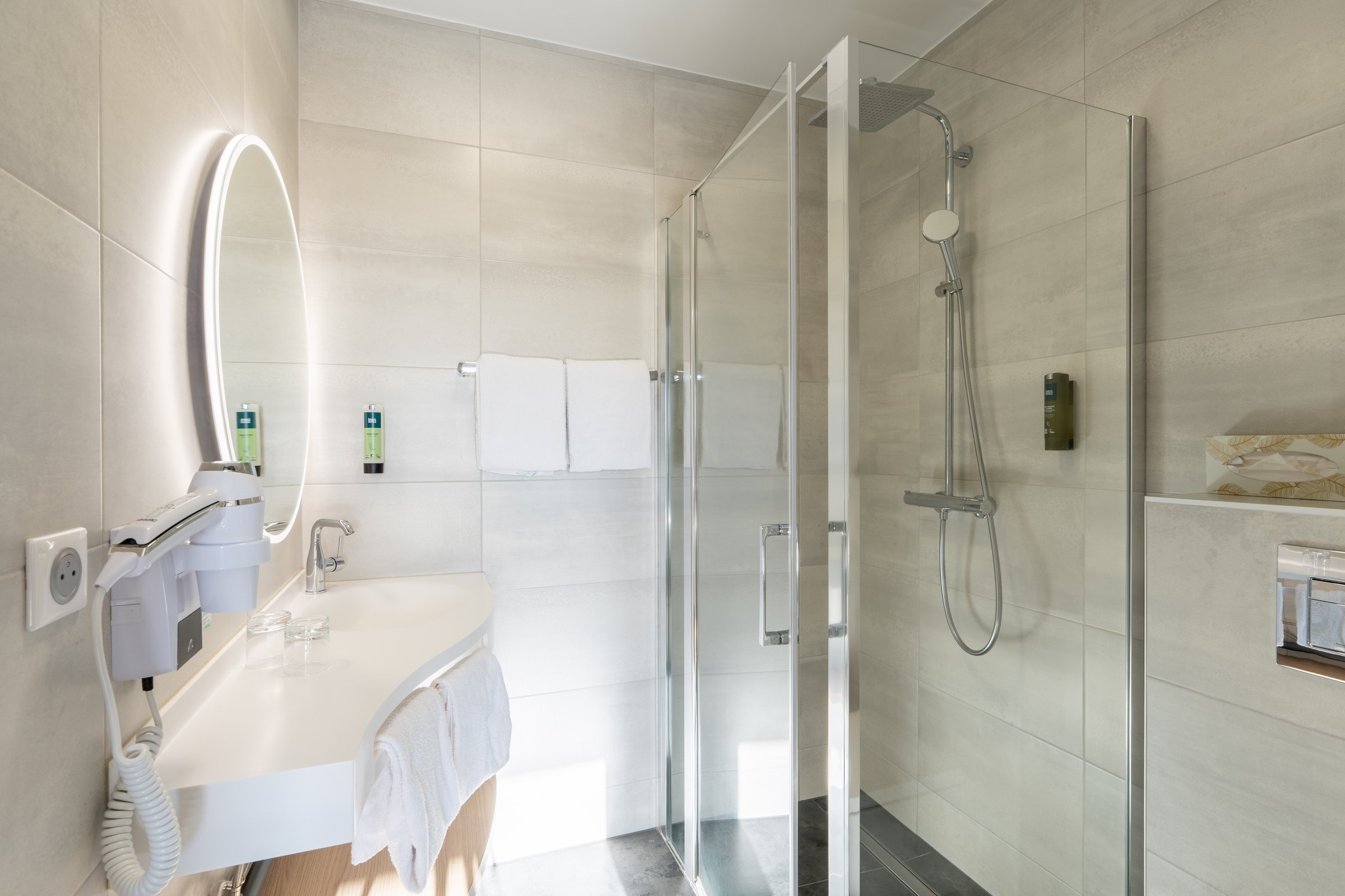 Bathroom with glass shower and illuminated mirror