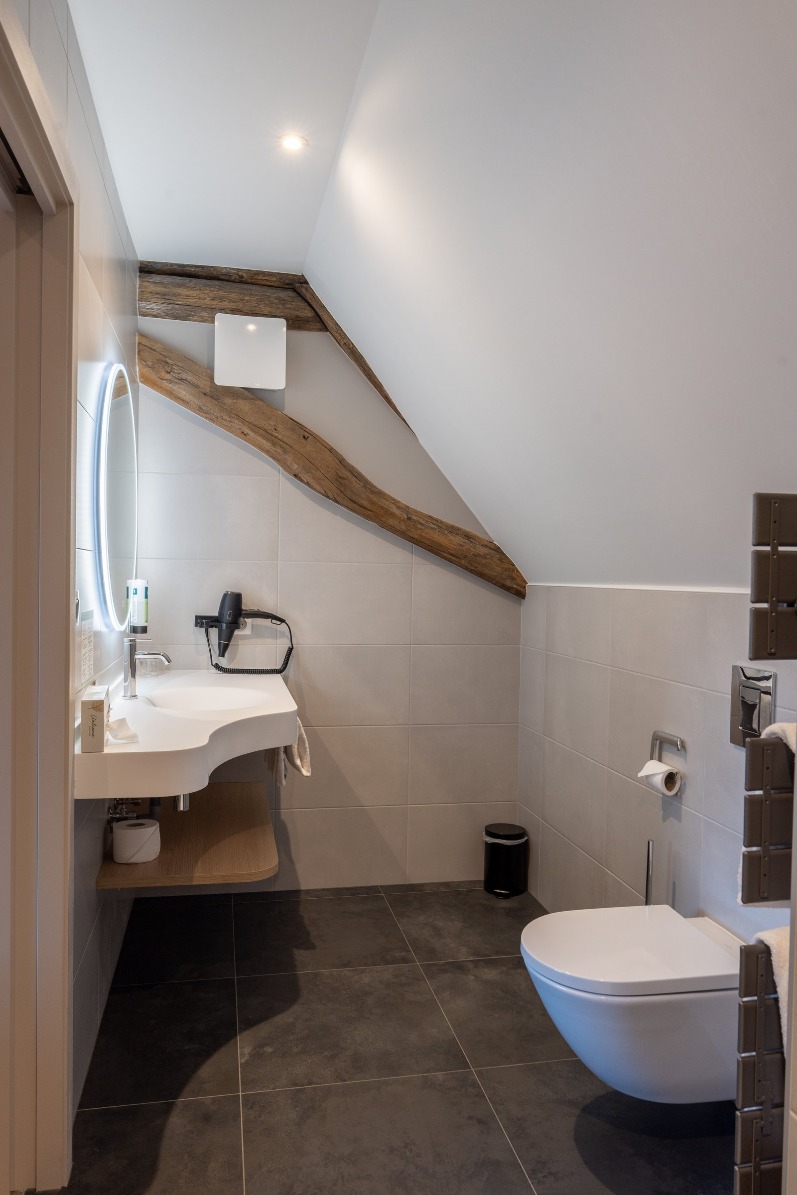 Bathroom under the eaves with exposed beams
