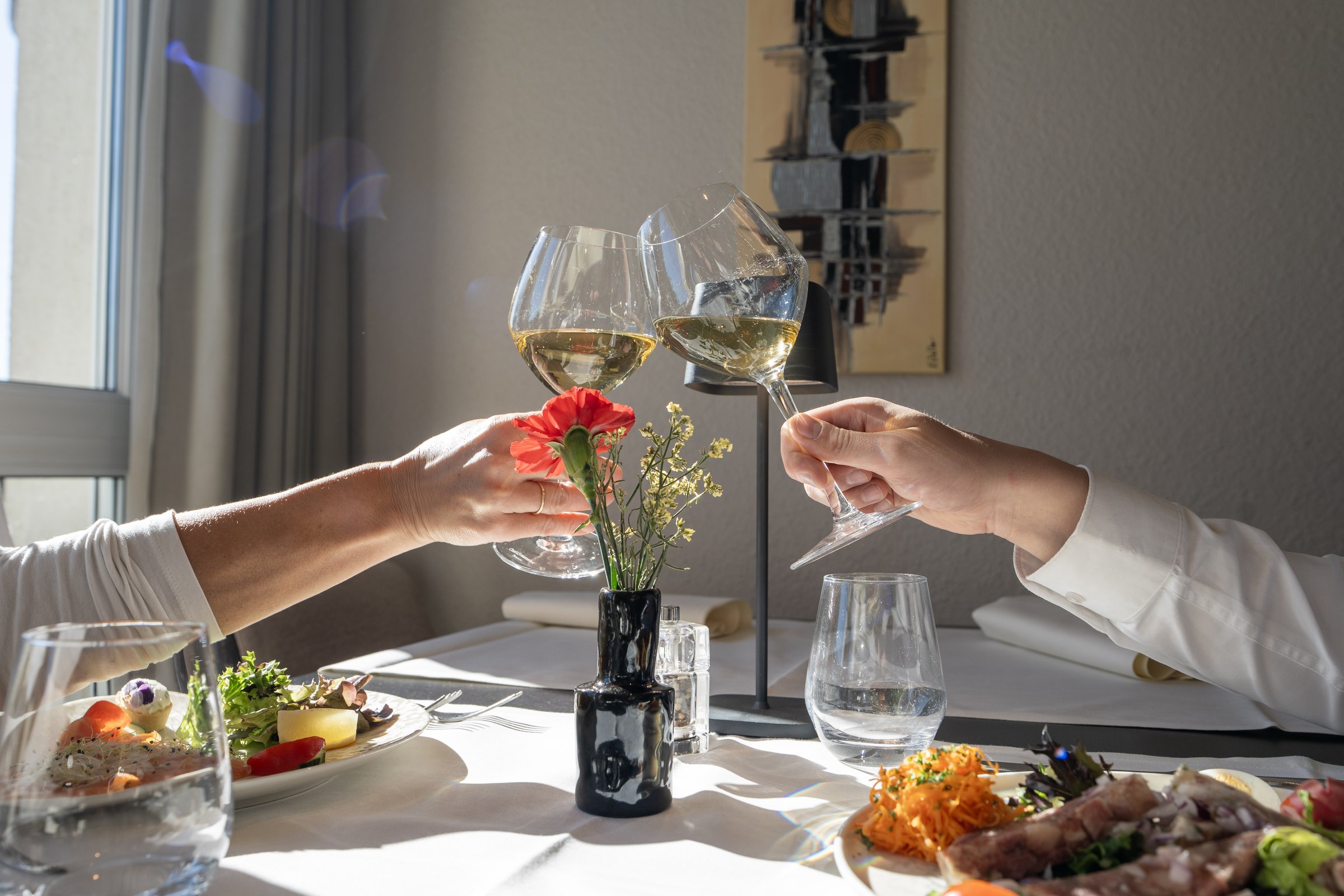 Guests raising glasses of white wine at the restaurant