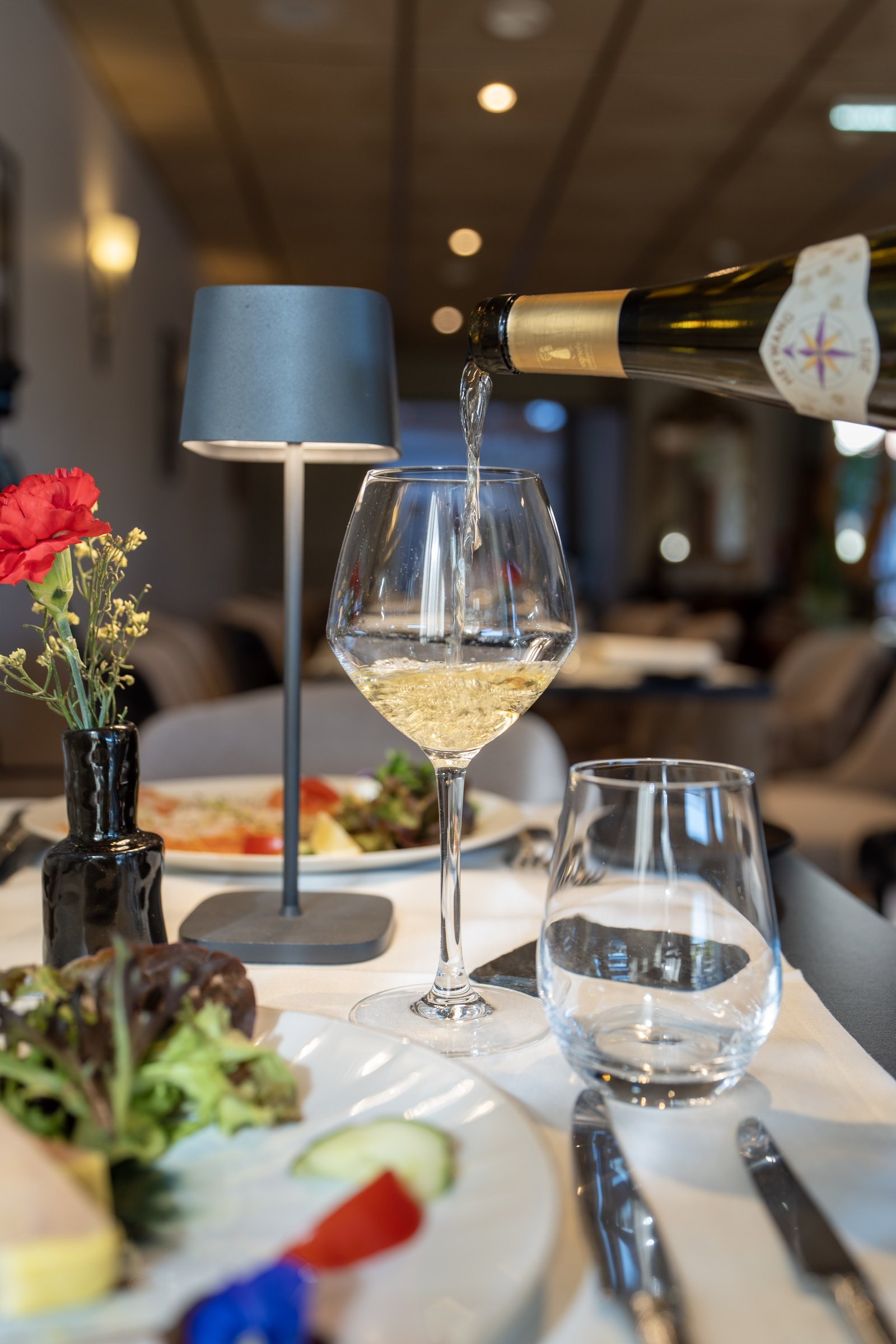 White wine poured into a glass at the table