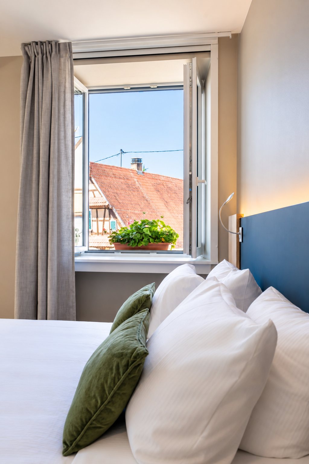 Pillows and an open window over the village rooftops