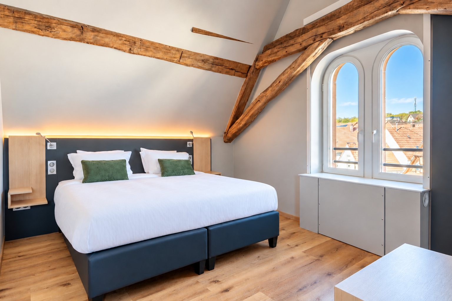 Signature junior suite under exposed roof beams with arched windows at the Ritter’Hoft